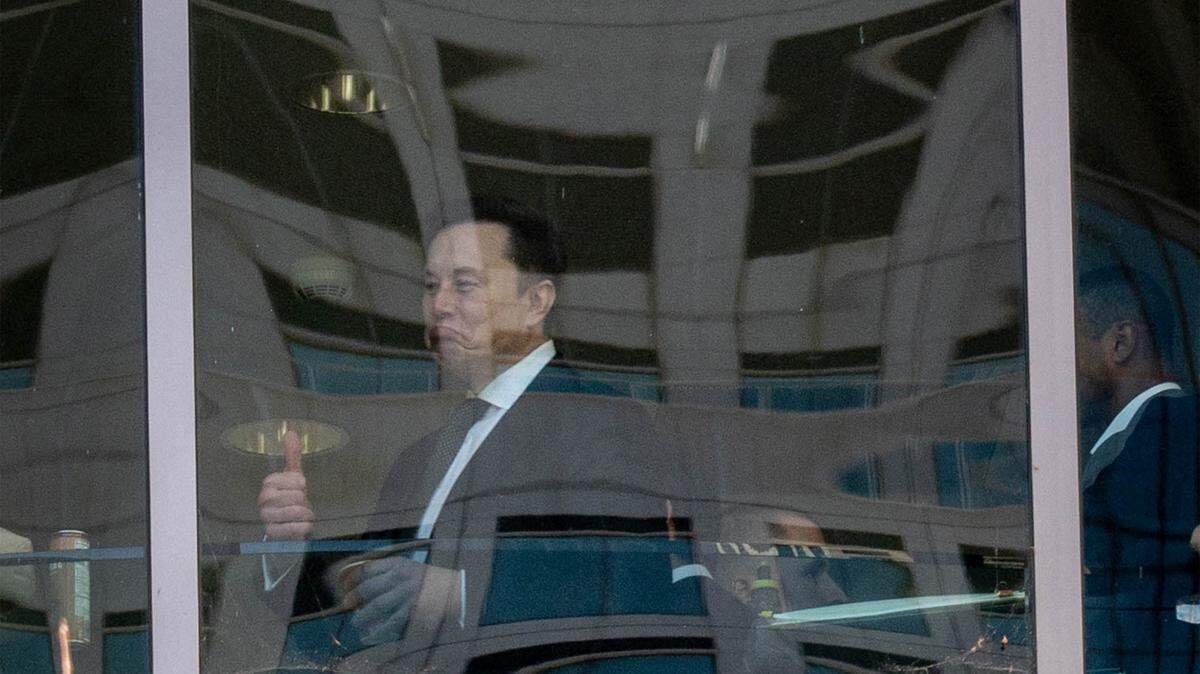 Elon Musk es visto a través de una ventana haciendo un gesto de “pulgar arriba” en el Tribunal Federal Ronald V. Dellums en Oakland, California, durante un receso del juicio entre Elon Musk y OpenAI el 29 de abril de 2026.