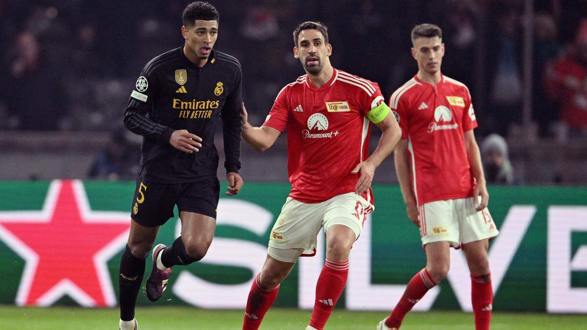 Jude Bellingham (izq.), del Real Madrid, conduce ante los jugadores del Union Berlin Rani Khedira y Janik Haberer (der.),el 12 de diciembre de 2023 por el Grupo C de la Champions en Olympiastadion, en Berlín.