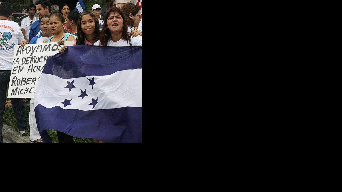 DECENAS DE manifestantes se dieron cita el lunes en Coral Way y la 71 avenida de Miami para apoyar el 
derrocamiento de Manuel Zelaya mediante un golpe de Estado.Debajo, José Ramirez participa en la 
manifestación junto a su hijo.