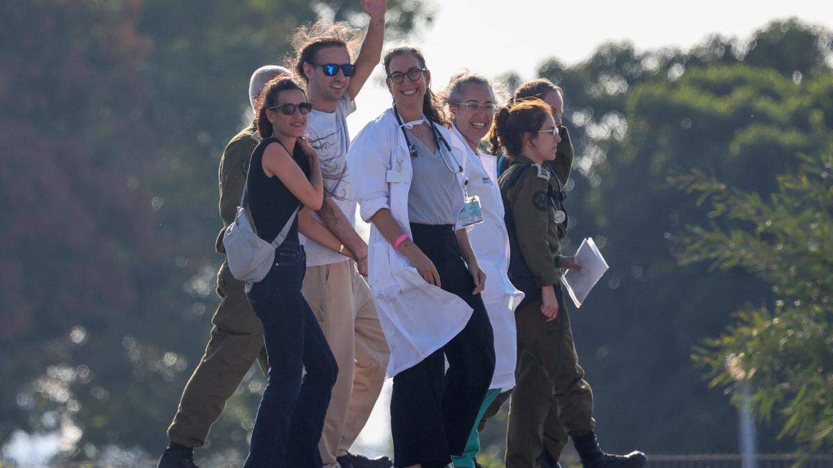 Israeli soldiers and medics accompany Ariel Cunio (2L) formerly held hostage in Gaza since October 2023 by Palestinian militants, upon his arrival at the Sheba Tel-HaShomer Medical Centre in Ramat Gan on October 13, 2025, alongisde former hostage Arbel Yehud (L) who was released in a previous exchange in January. (Photo by Ahmad GHARABLI / AFP) (Photo by AHMAD GHARABLI/AFP via Getty Images)