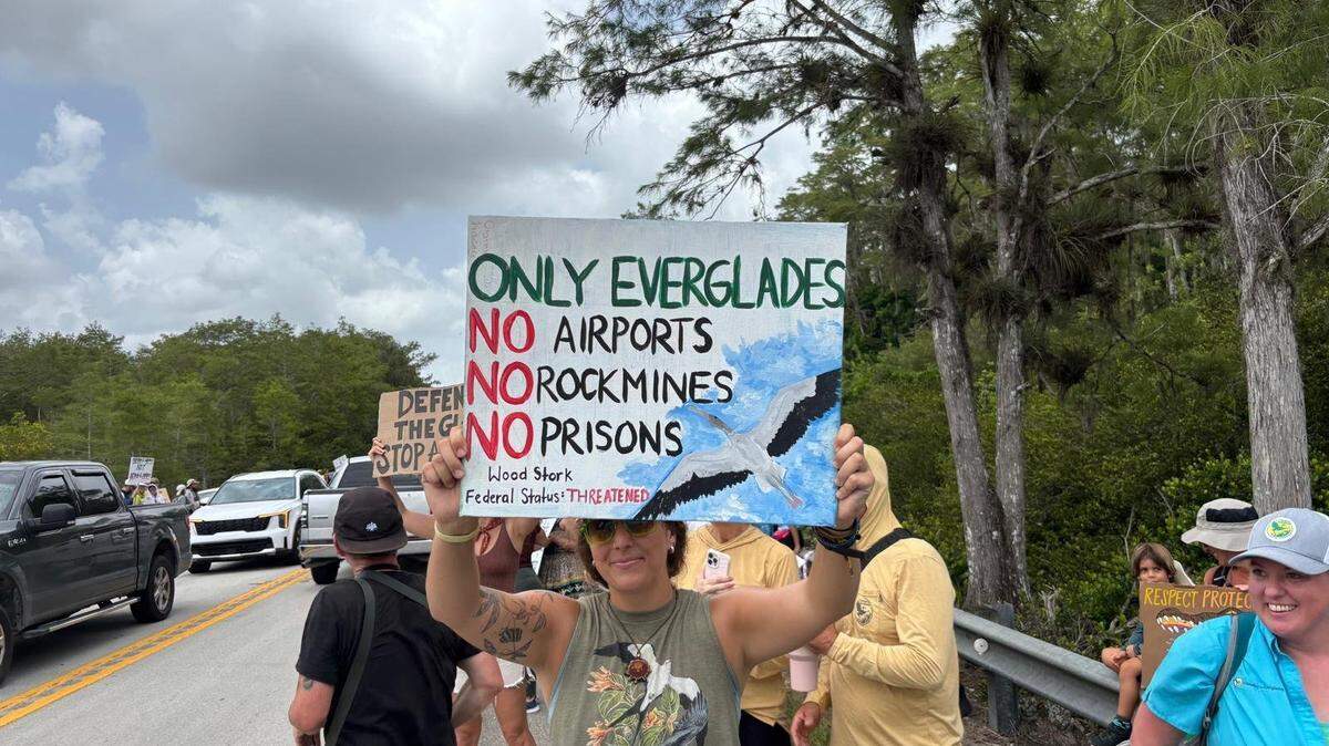 Manifestantes se congregan cerca del Aeropuerto de Entrenamiento y Transición Dade-Collier, donde se está el centro de detención para migrantes Alligator Alcatraz. Los manifestantes argumentan que el centro de detención podría dañar el frágil ecosistema de la zona.