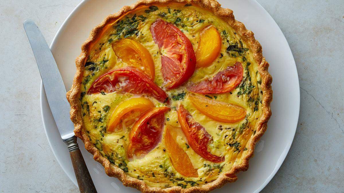 Tarta de tomates reliquia sazonada con albahaca y orégano frescos. Estilista de alimentos: Barrett Washburne.