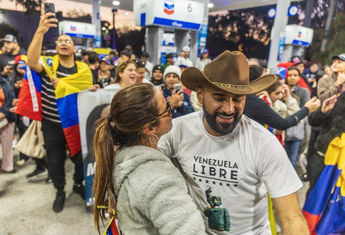 Julian Pantoja y Any González de Fernández se encontraban entre un grupo de venezolanos exiliados que viven en el sur de Florida celebrando frente a El Arepazo, en Doral, Florida, después de que Estados Unidos atacara Venezuela y capturara al líder venezolano Nicolás Maduro, el 3 de enero de 2026.
