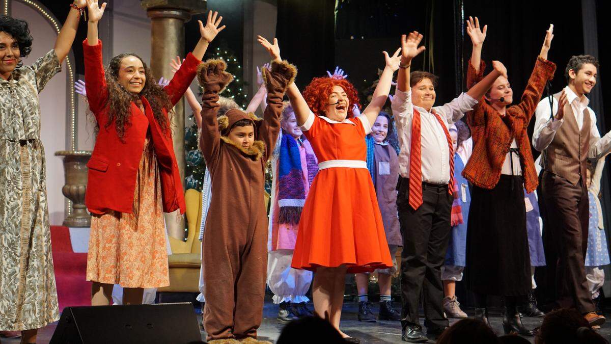 Al terminar la presentación del musical “Annie”, los alumnos responden al aplauso entusiasta del público.     