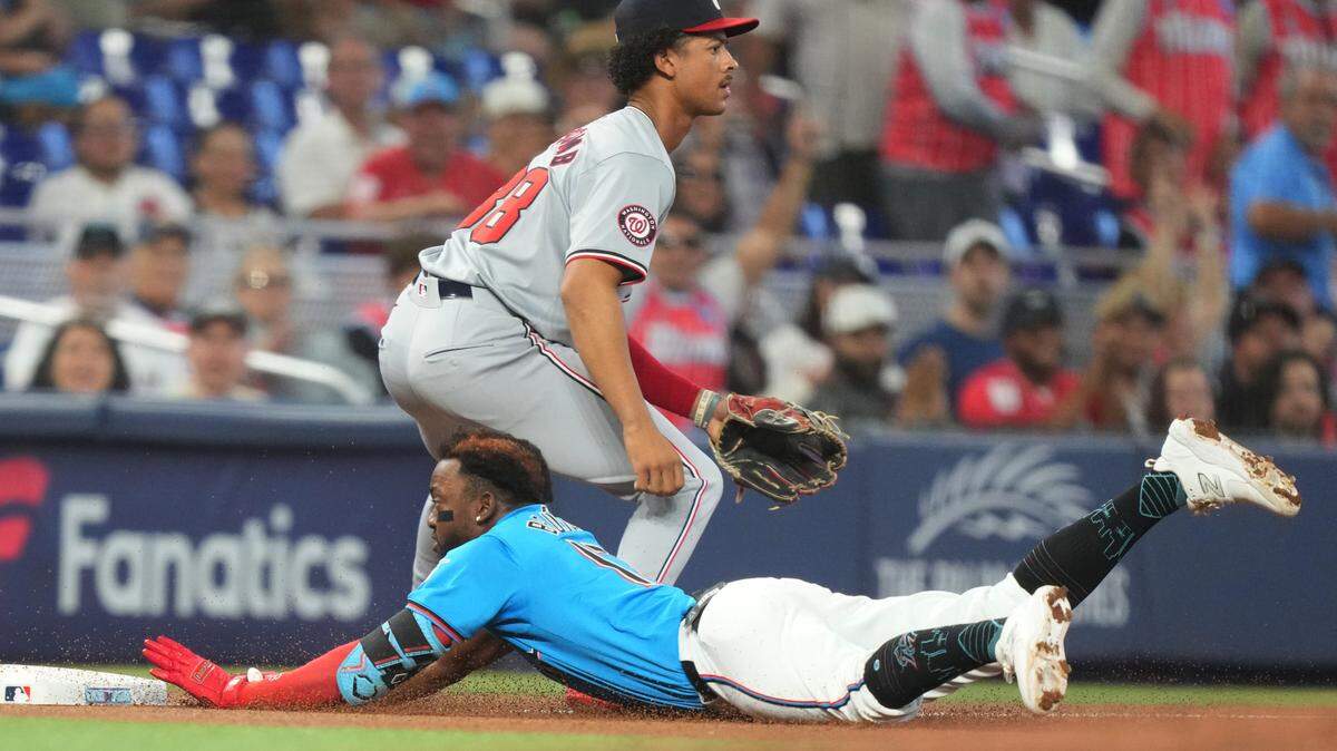 El antesalista de los Miami Marlins, Vidal Brujn (17), se deslisa en la tercera base con un triple mientras la tercera base de los Washington Nationals, Trey Lipscomb (38), espera la pelota en la primera entrada ets 28 de abril de 2024; en el LoanDepot Park., en Miami, Florida.