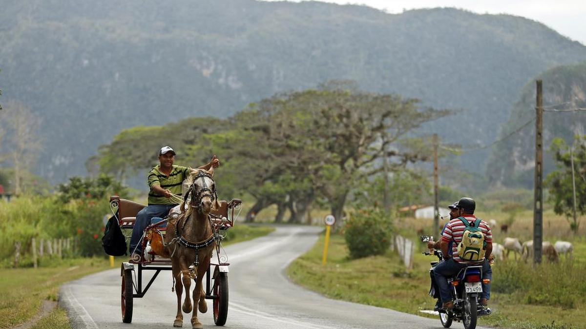 Una carreta y una motocicleta en la carretera del valle de Viñales, el 24 de marzo de 2016.