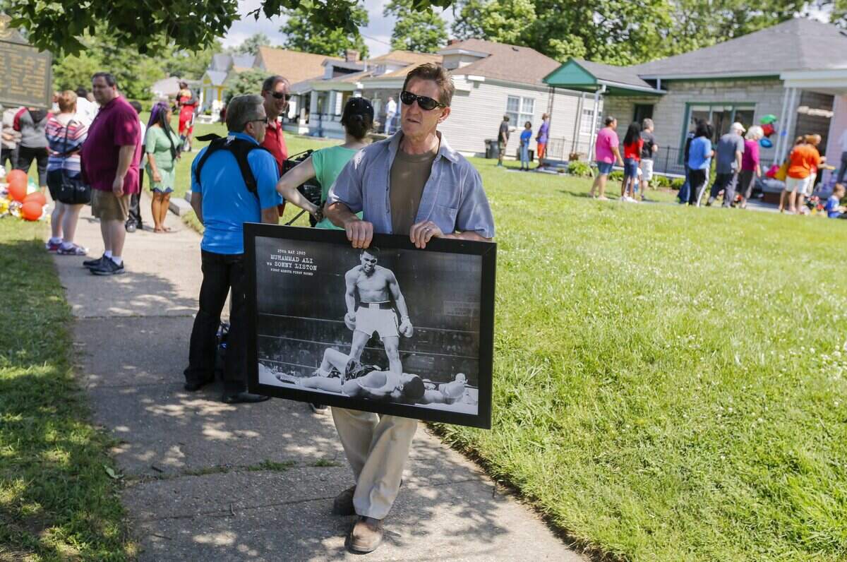 Un  seguidor de Muhammad Ali sostiene una fotografía del gran boxeador en Louisville (Kentucky), dos días después de la muerte de éste.