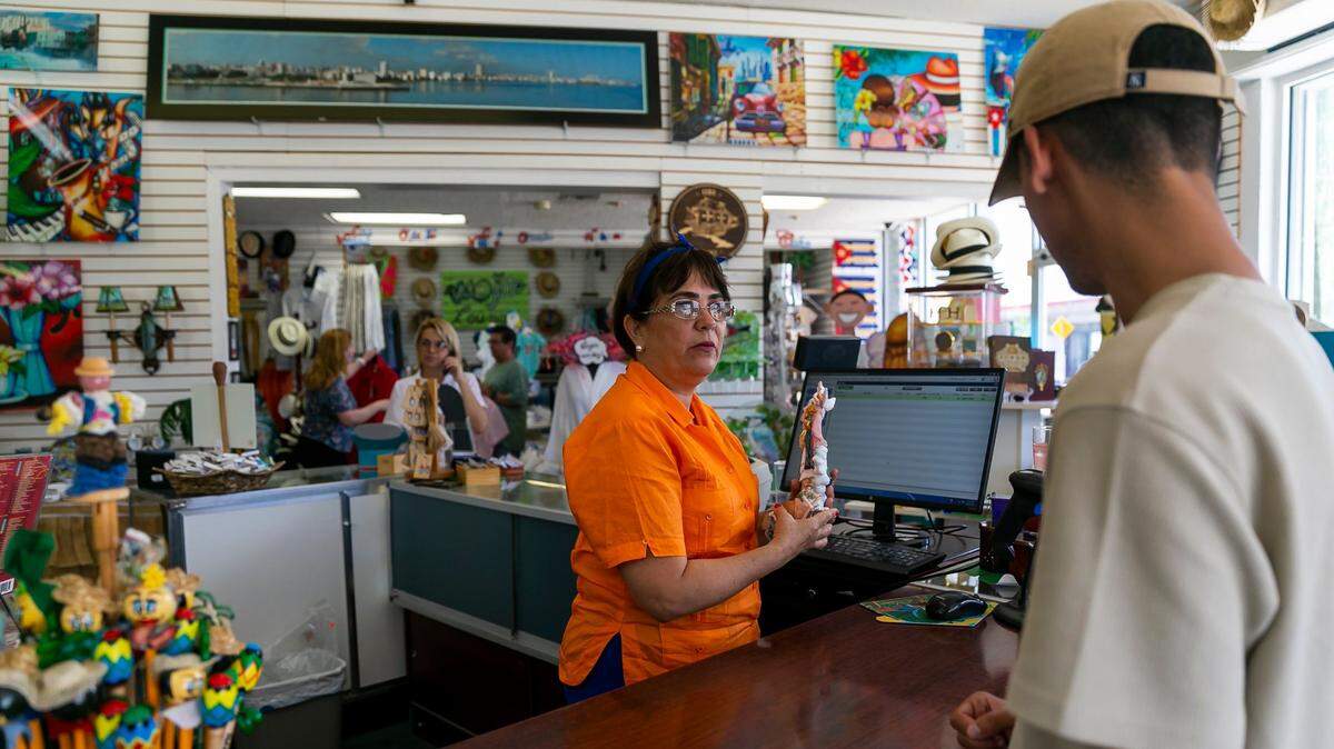 Moraima García, empleada de Sentir Cubano, le cobra un artículo a Kevin Lozada que visita la tienda en La Pequeña Habana, el 28 de junio de 2022. Los alquileres de las viviendas se han disparado 54% en la zona en comparación con hace un año, lo que ha obligado a muchos vecinos a marcharse.