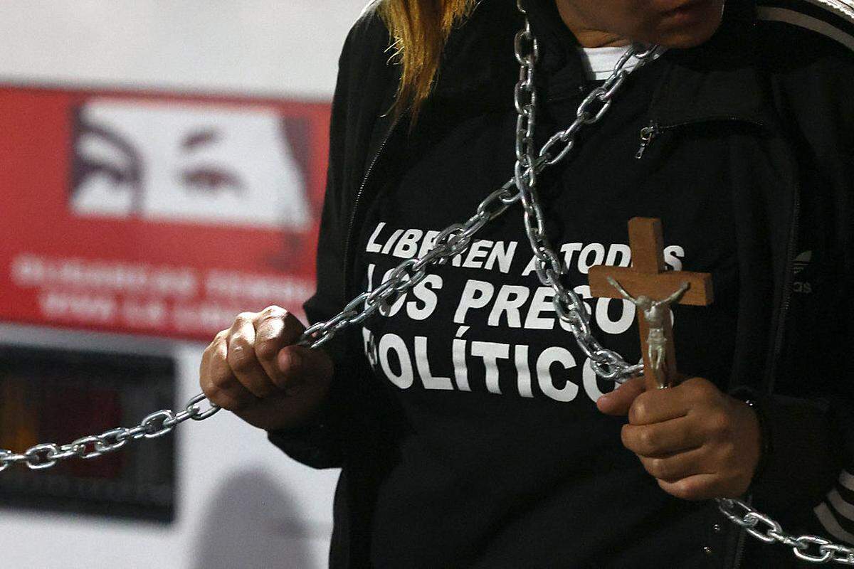 Una persona sostiene un crucifijo y unas cadenas para exigir la liberación de los presos políticos frente a la prisión de la Zona 7 de la Policía Nacional Bolivariana (PNB) en Caracas, el viernes 30 de enero de 2026.