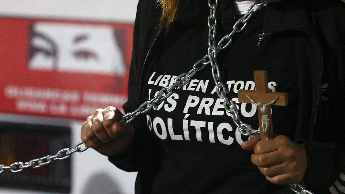 Una persona sostiene un crucifijo y unas cadenas para exigir la liberación de los presos políticos frente a la prisión de la Zona 7 de la Policía Nacional Bolivariana (PNB) en Caracas, el viernes 30 de enero de 2026.