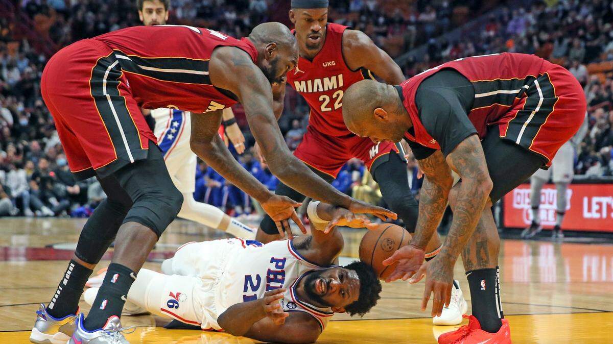 El centro de los Philadelphia 76ers, Joel Embiid (21), rodeado por el centro Dewayne Dedmon (21), el alero Jimmy Butler (22) y el alero PJ Tucker (17) pierde el balón en el segundo cuarto en el FTX Arena de Miami el sábado 1 de enero. 15, 2022.