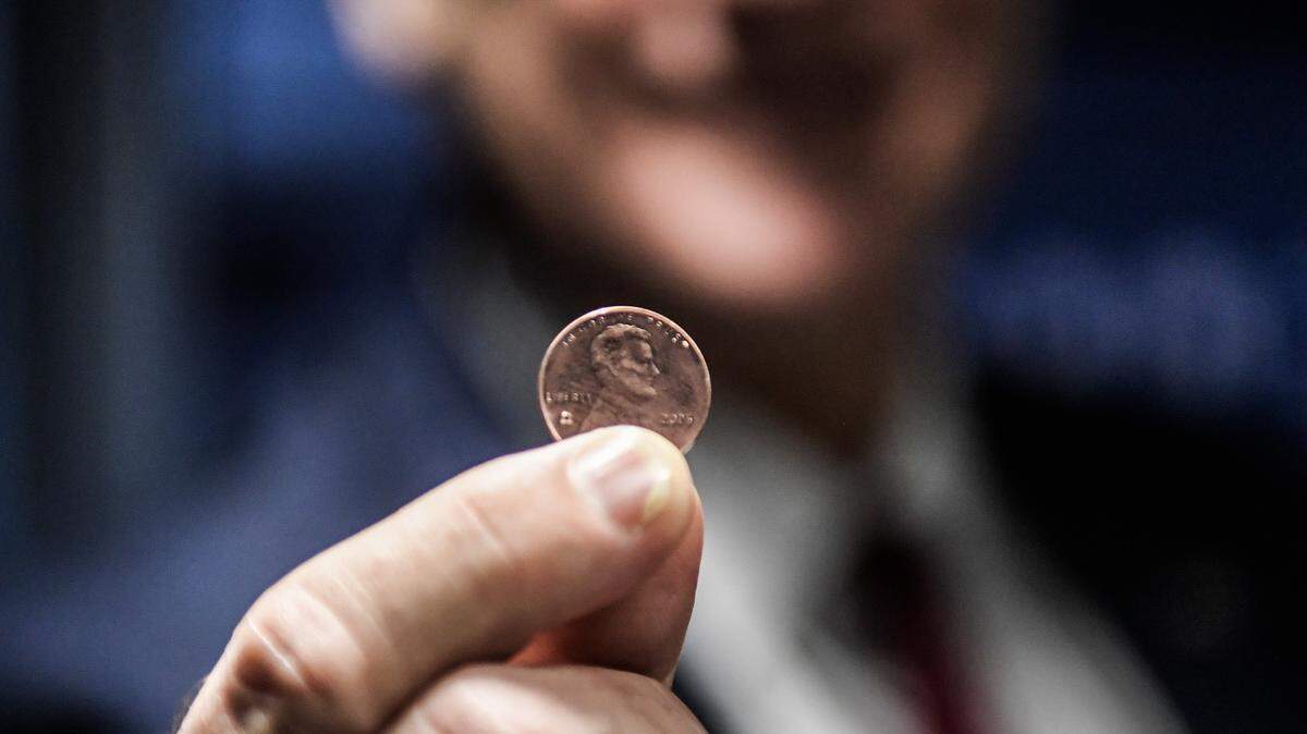 PHILADELPHIA, PENNSYLVANIA - NOVEMBER 12: Treasurer of the United States Brandon Beach holds the last penny stamped at the US Mint on November 12, 2025 in Philadelphia, Pennsylvania. Beach pressed the final pennies at an event held at the facility. The pennies pressed bear a special 'Omega' and will not be put in circulation, but will be auctioned off. (Photo by Matthew Hatcher/Getty Images)