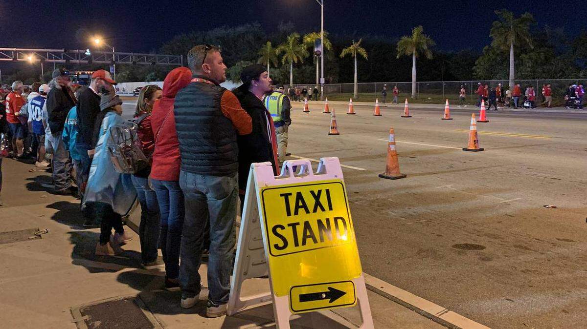 Los fanáticos esperan en la fila un taxi afuera del Hard Rock Stadium en Northwest 199th Street después del Super Bowl 54.