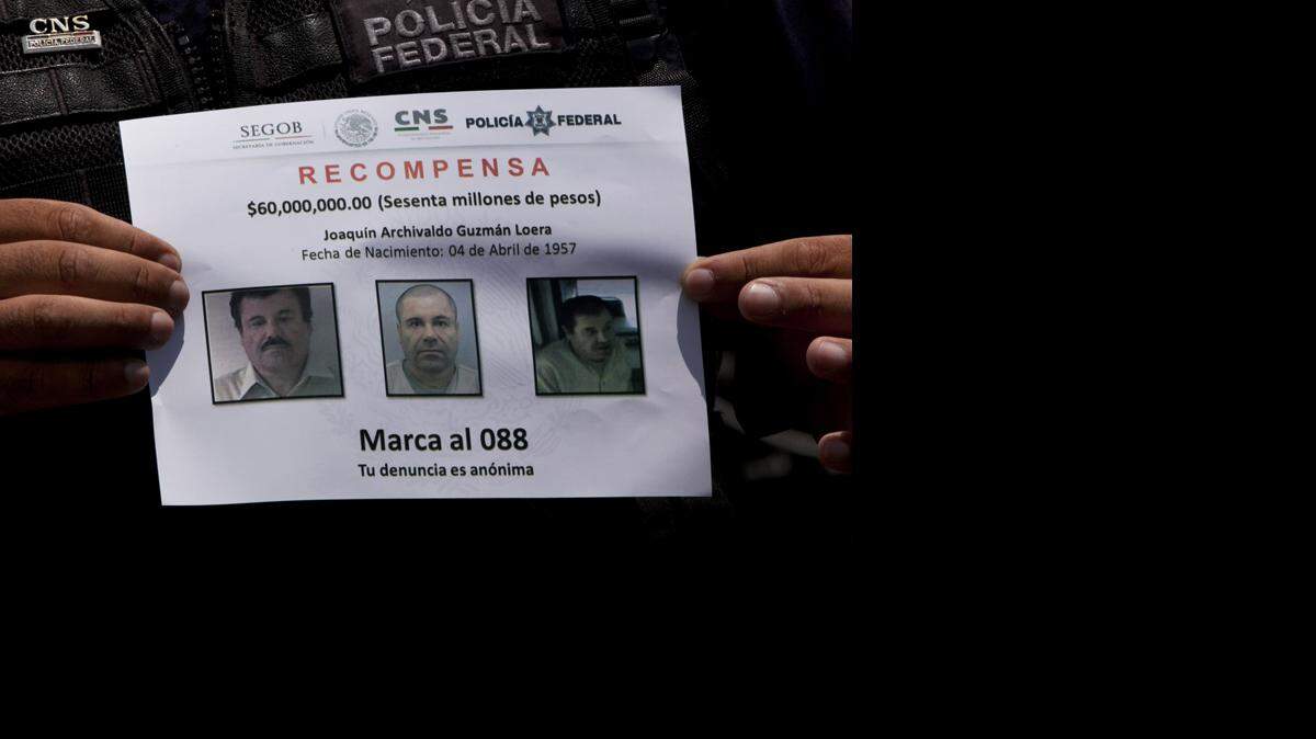 En esta imagen de archivo, el 16 de julio de 2015, un policía federal muestra un aviso de recompensa por información que lleve a la captura del narcotraficante Joaquín "El Chapo" Guzmán, fugado de la prisión de máxima seguridad de Altiplano a través de un túnel subterráneo en Almoloya, oeste de  México. 