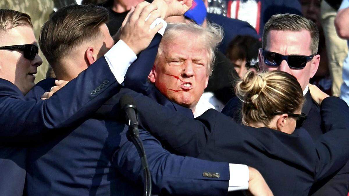 El candidato presidencial republicano de los Estados Unidos, el expresidente Donald Trump, está rodeado por agentes del Servicio Secreto de los Estados Unidos en Butler, Pensilvania, el 13 de julio de 2024.