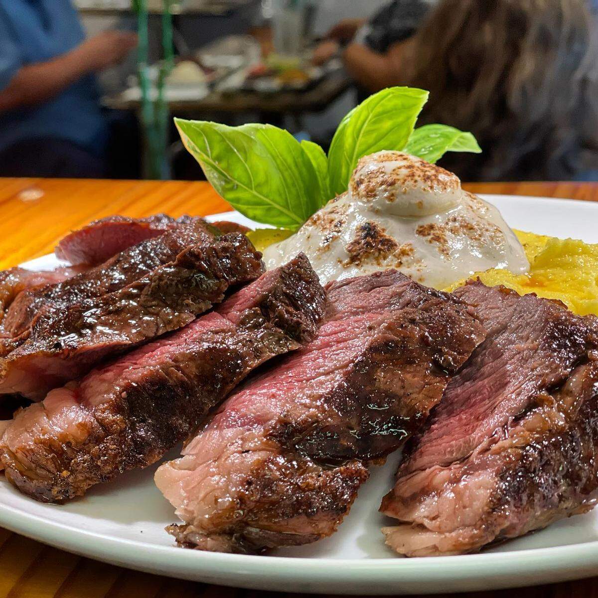 Bife de chorizo angosto con polenta a la crema y burrata casera rellena con tomate seco, crema y aceite de trufa blanca de La Cosecha.