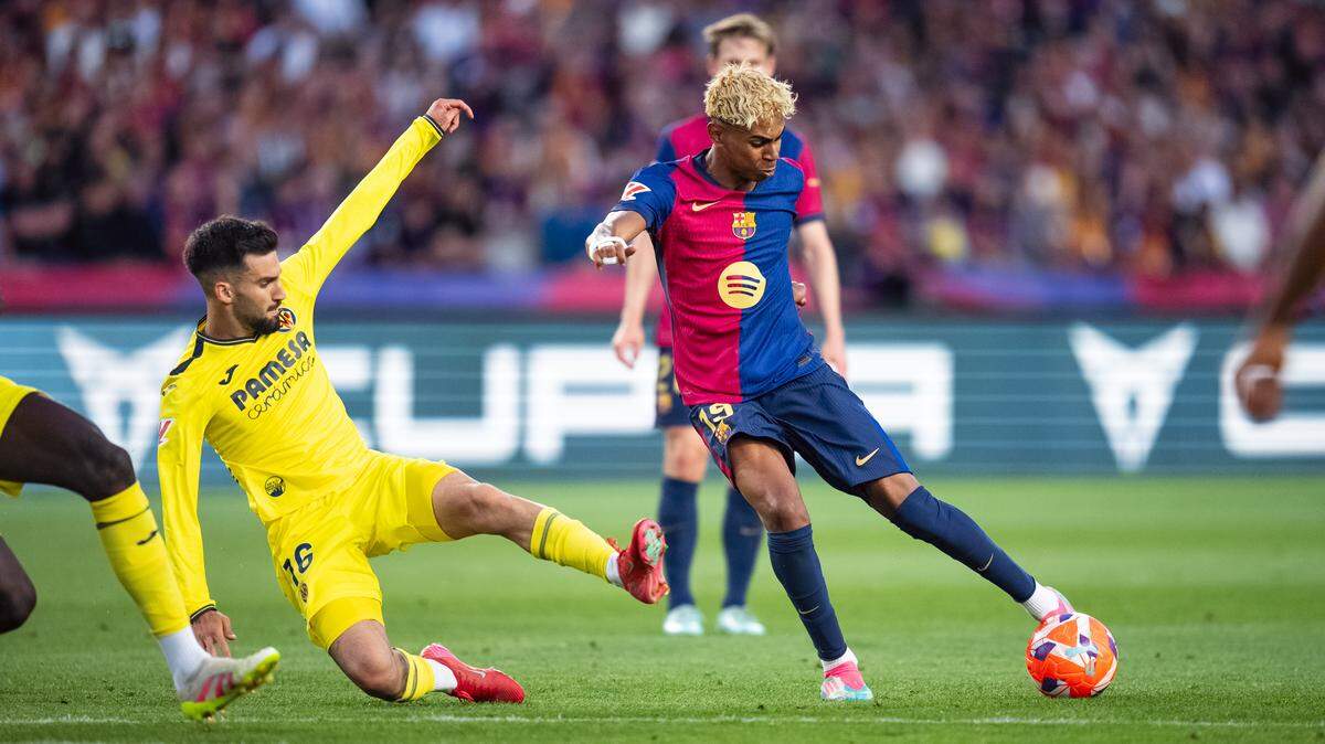 El delantero de Barcelona Lamine Yamal dispara a puerta ante la defensa de Alex Baena, de Villarreal, en el partido de la liga española celebrado el 18 de mayo de 2025 en Barcelona.