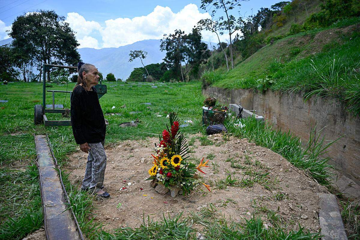 Carmen Navas stands next to the grave of her son, political prisoner Victor Quero Navas, at the Metropolitano Monumental del Este cemetery in Caracas on May 11, 2026. Venezuelan authorities exhumed on May 8, 2026 the body of Victor Hugo Quero Navas, a political prisoner whose death occurred in July 2025 but was officially acknowledged on May 7. After the exhumation, Carmen Navas was able to identify her son's body and bury him in another cemetery. (Photo by Maryorin Mendez / AFP via Getty Images)
