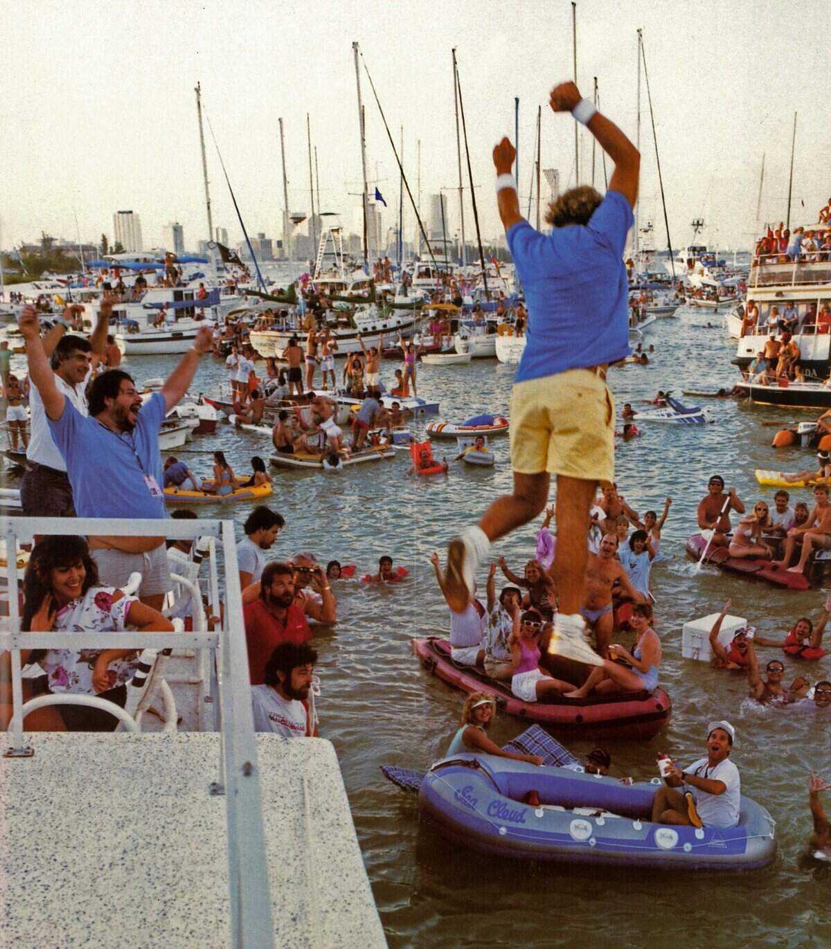 El cantante Jimmy Buffett salta al agua desde el escenario en 1985 mientras los fans en embarcaciones rodean el Miami Marine Stadium.