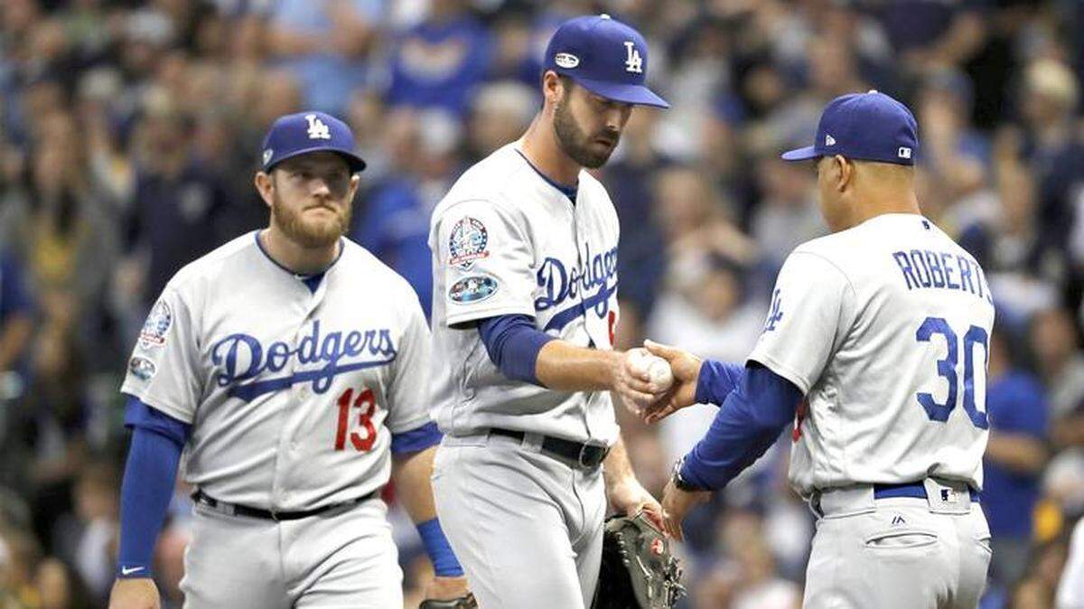 El manager de los Dodgers Dave Roberts (30) toma la peleta del relevista Dylan Floro (51) en un juego de la Serie de Campeonato entre los Dodgers y los Cerveceros el 19 de octubre del 2018.