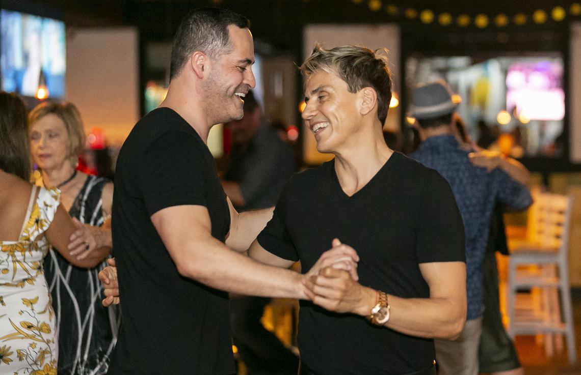 Rodrigo Romero, 50, left, Luis Vivas, 46, a co-creator of Tango Out, dance tango at The Reef Beach Bar in Miami Beach, Florida on Monday, October 21, 2019.