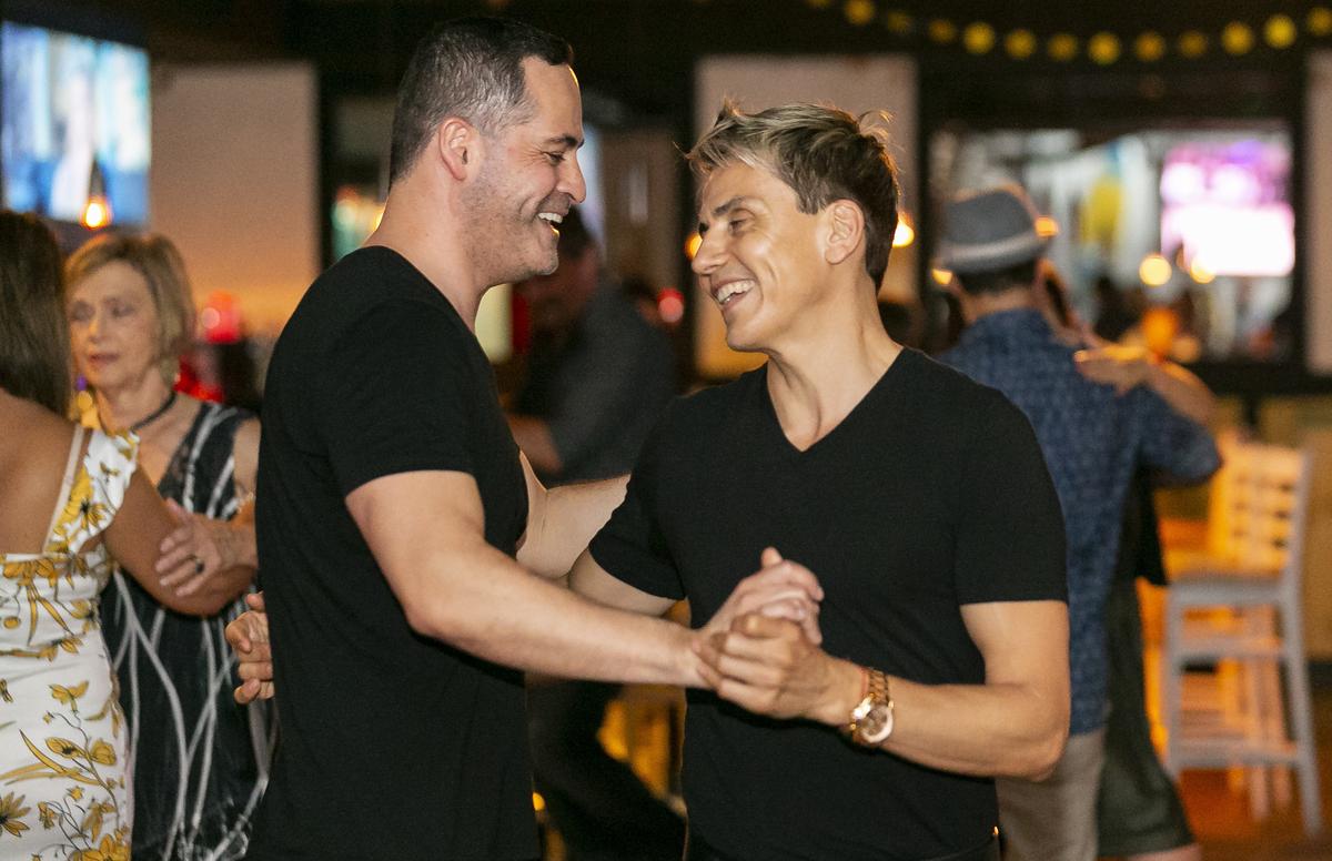Rodrigo Romero, de 50 años, a la izquierda, y Luis Vivas, de 46, co-creador de Tango Out, bailan juntos en The Reef Beach Bar en Miami Beach, Florida, el lunes 21 de octubre de 2019.
