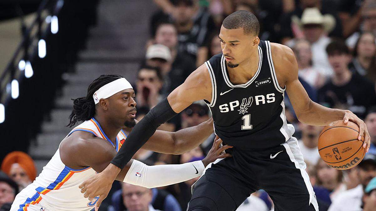 El astro de los Spurs Victor Wembanyama (der.) anotó 28  puntos y lideró el triunfo de su equipo 118-91 ante el Thunder de Oklahoma City, en el sexto partido de la final de la Conferencia Oeste, celebrado el 28 de mayo de 2026 en San Antonio. 