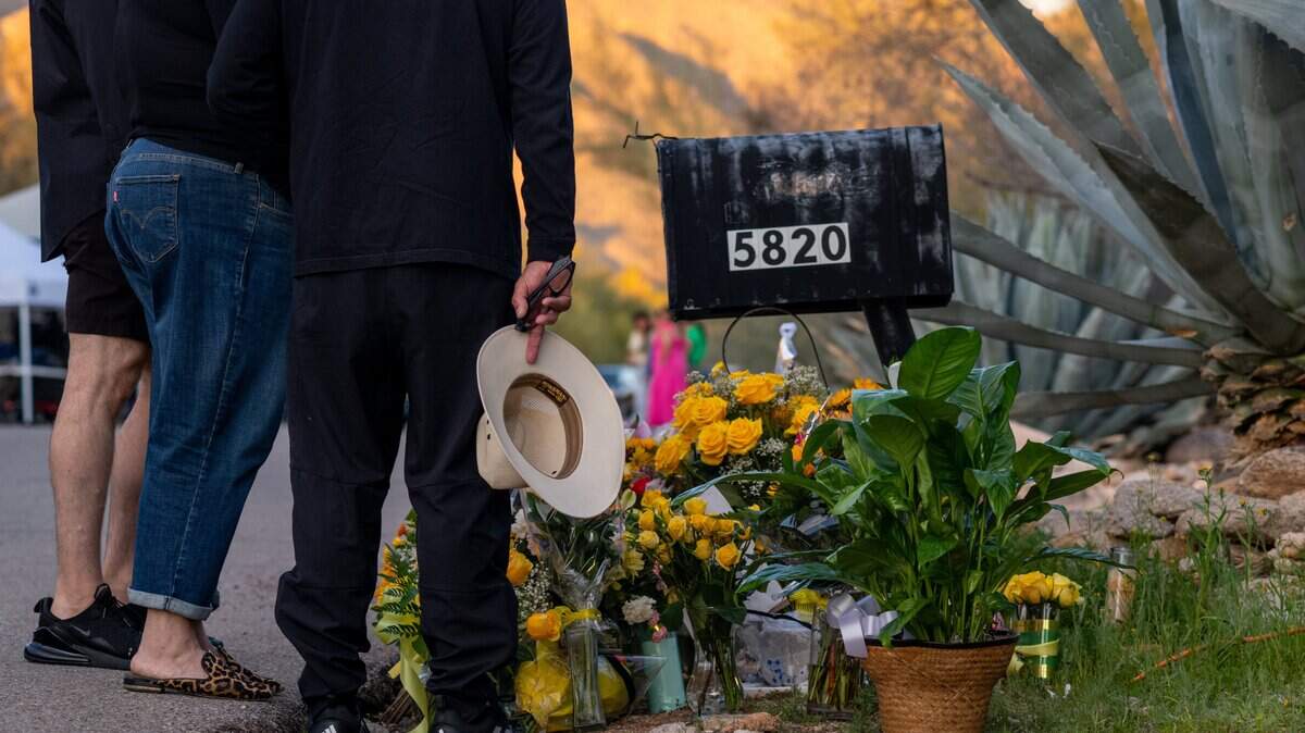 Personas rinden homenaje en un memorial improvisado frente a la residencia de Nancy Guthrie el 15 de febrero de 2026 en Tucson, Arizona.