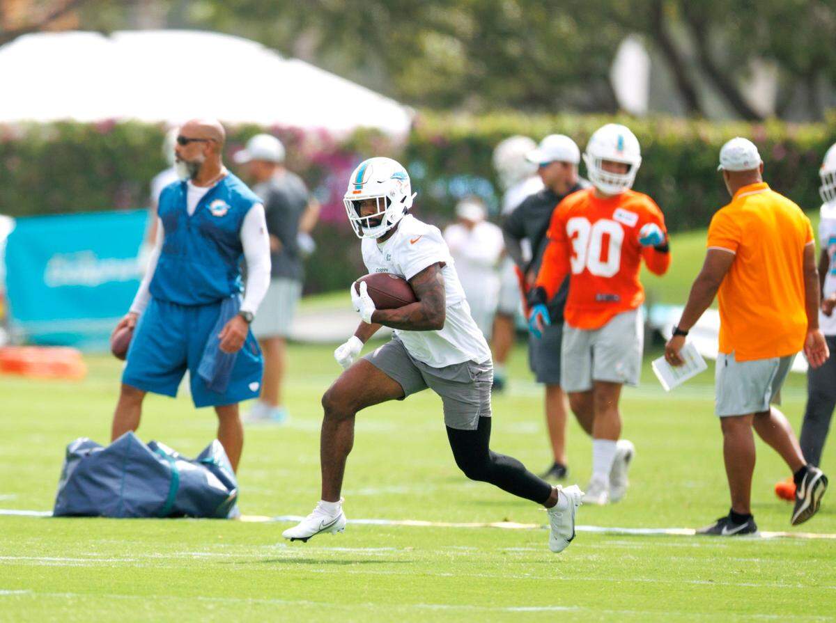 El running back Raheem Mostert corre con el ovoide en la práctica del equipo celebrada el 27 de julio de 2022 en Miami Gardens, Florida.