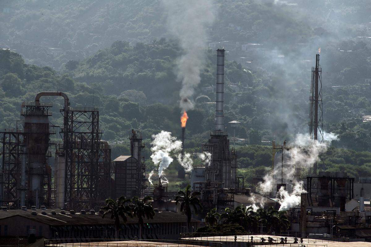 View of an oil refining plant of state-owned Petroleos de Venezuela (PDVSA) in Puerto La Cruz, Anzoategui state, Venezuela, on November 4, 2021. - Leaks, rusted pipes, pieces of broken equipment scattered about and staircases leading nowhere: Lake Maracaibo's old oilfield is a metaphor for the once-flourishing Venezuelan petroleum industry now on its knees. Zulia state, where the lake is, was the birthplace of Venezuela's oil industry more than a century ago. (Photo by Yuri CORTEZ / AFP) (Photo by YURI CORTEZ/AFP via Getty Images)