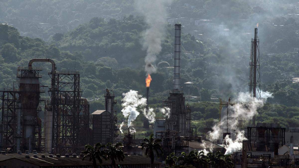 View of an oil refining plant of state-owned Petroleos de Venezuela (PDVSA) in Puerto La Cruz, Anzoategui state, Venezuela, on November 4, 2021. - Leaks, rusted pipes, pieces of broken equipment scattered about and staircases leading nowhere: Lake Maracaibo's old oilfield is a metaphor for the once-flourishing Venezuelan petroleum industry now on its knees. Zulia state, where the lake is, was the birthplace of Venezuela's oil industry more than a century ago. (Photo by Yuri CORTEZ / AFP) (Photo by YURI CORTEZ/AFP via Getty Images)