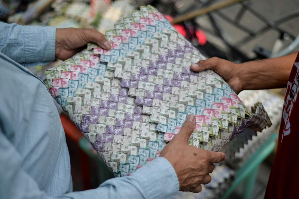 Un artesano muestra una cartera hecha con bolívares en una calle de Cúcuta, Colombia, en la frontera con Venezuela.