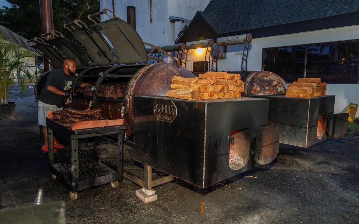 Aaron Jean Pierre, jefe de parrillas de Apocalypse BBQ, revisa algunas pechugas de res en los gigantescos ahumadores de barbacoa del popular restaurante.