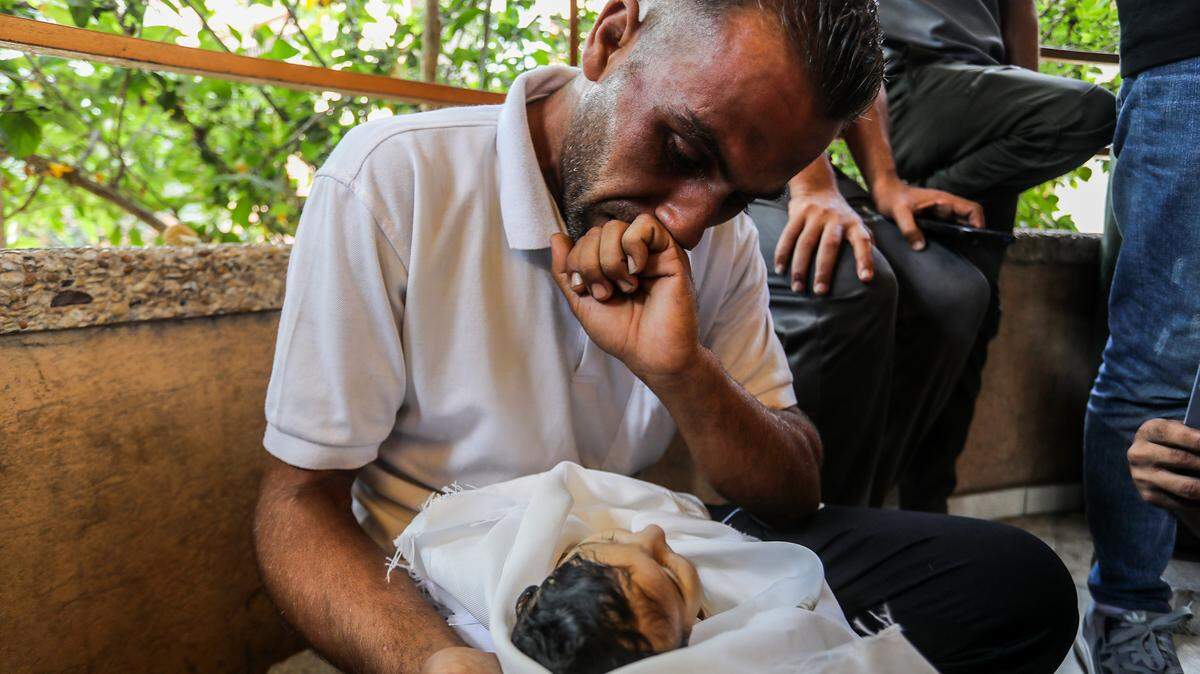 22 August 2025, Palestinian Territories, Khan Yunis: The father of five-month-old Ghadeer Brika, looks at his daughter's lifeless body at Nasser Medical Complex in Khan Yunis, southern Gaza Strip. She died after suffering from severe malnutrition due to the Israeli blockade. Famine has been confirmed for the first time in an area of the embattled Gaza Strip, according to the international authority responsible for monitoring food security. Photo: Abed Rahim Khatib/dpa/Sipa USA