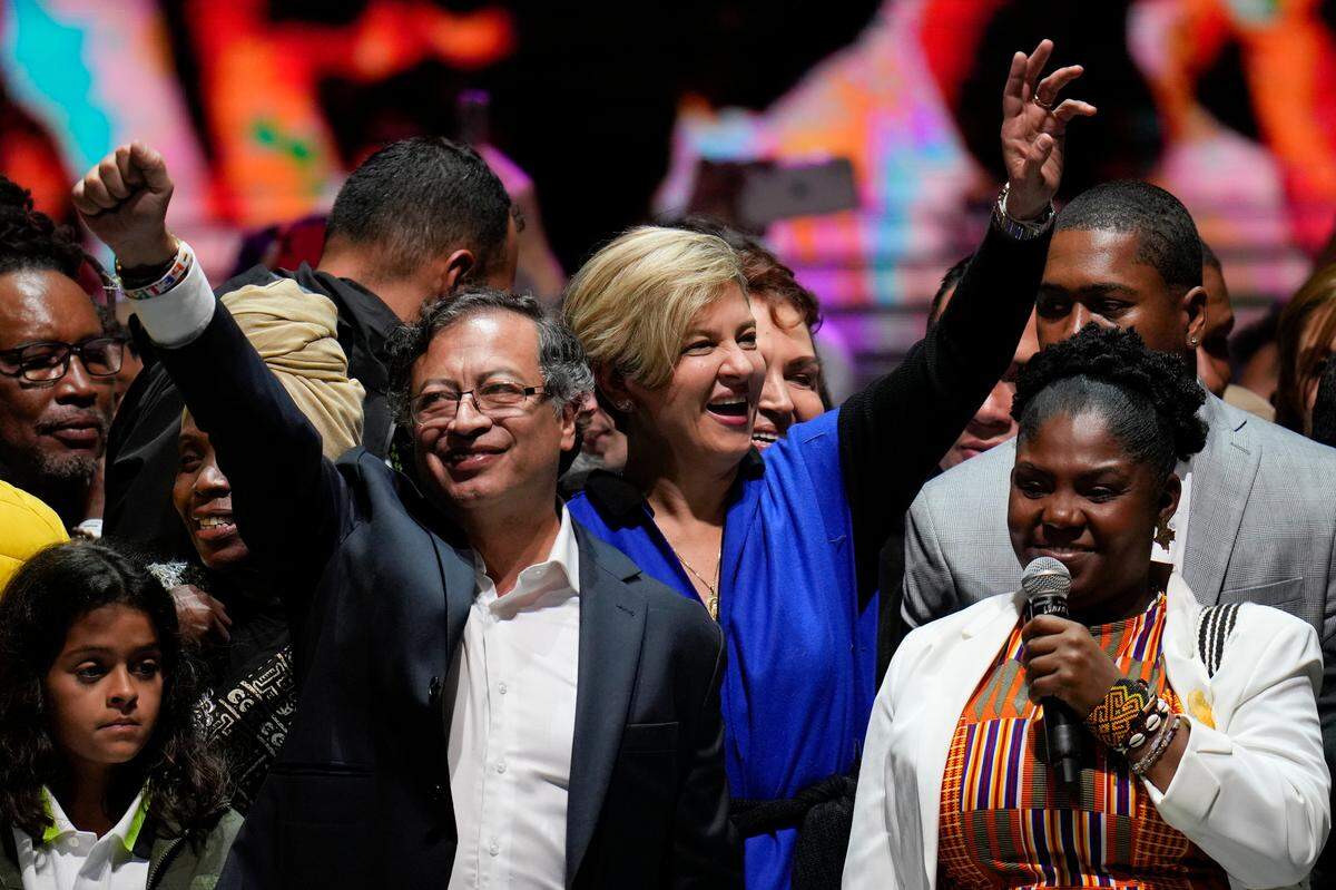 El presidente electo de Colombia Gustavo Petro (izquierda), su esposa Verónica Alcocer, atrás al centro, y su compañera de fórmula Francia Márquez celebran ante sus seguidores después de ganar la segunda vuelta de las elecciones presidenciales en Bogotá, el domingo 19 de junio de 2022.