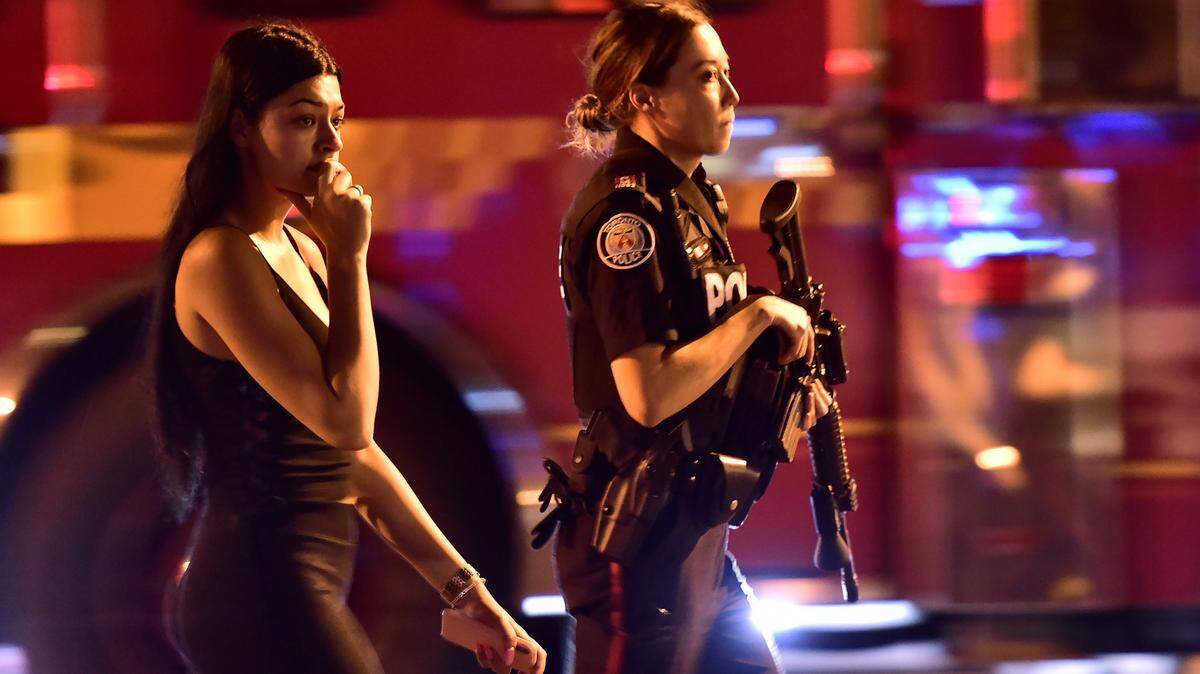 Una agente de la Policía de Toronto acompaña a una transeúnte tras el tiroteo que dejó tres muertos la noche del 22 de julio del 2018.