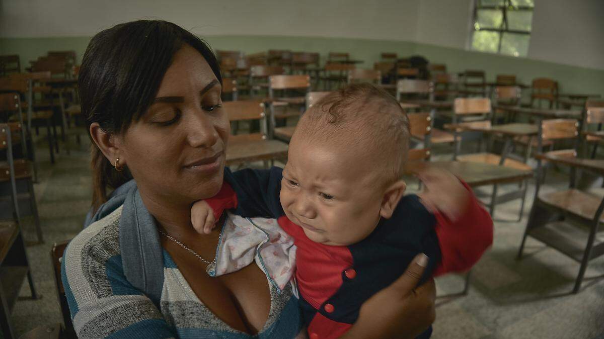 La alumna Moraxis Granado, de 30 años, carga a su bebe después de una clase en la Universidad Central de Venezuela.