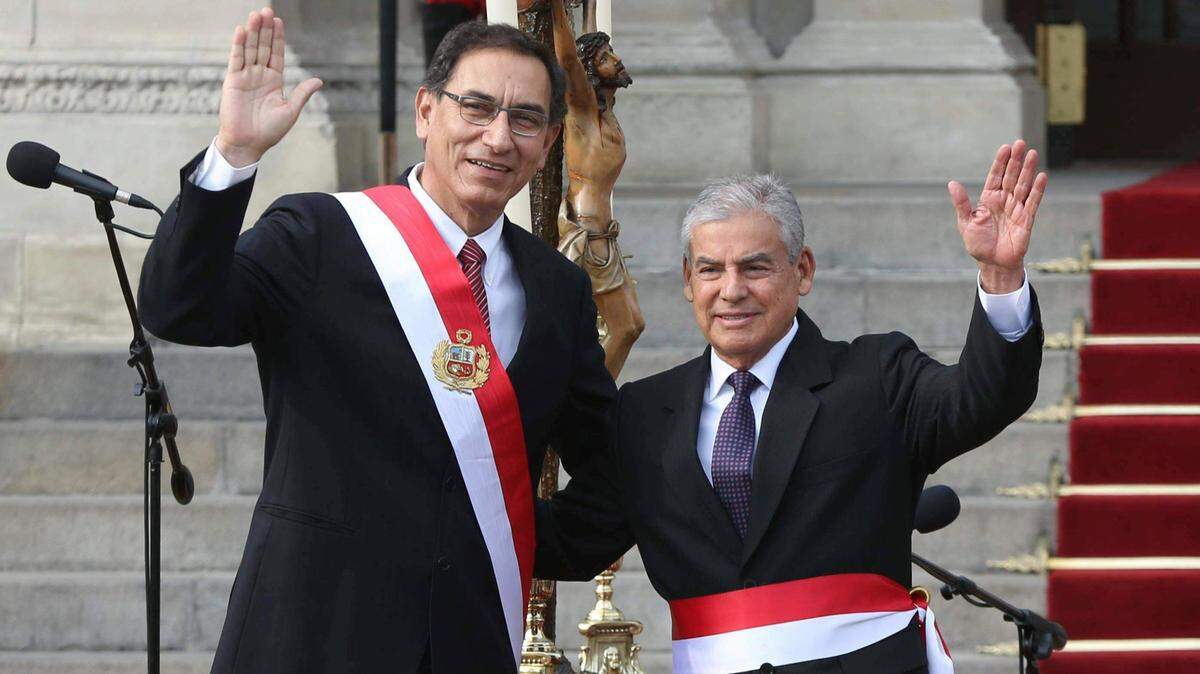El presidente de Perú, Martín Vizcarra, a la izquierda, saluda junto a su jefe de gabinete, César Villanueva, durante una ceremonia de juramento del nuevo gabinete en el palacio de gobierno en Lima, Perú. Archivo. (AP Photo/Martin Mejia)