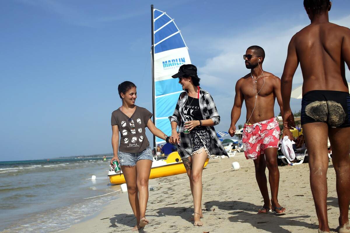 La pareja formada por Yuli Delgado (izq), de 27 años, y Betsy Conde (der), de 23, pasean por la playa Mi Cayito, en La Habana, Cuba, sitio de encuentro de la comunidad gay.