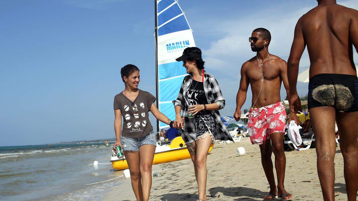 La pareja formada por Yuli Delgado (izq), de 27 años, y Betsy Conde (der), de 23, pasean por la playa Mi Cayito, en La Habana, Cuba, sitio de encuentro de la comunidad gay.