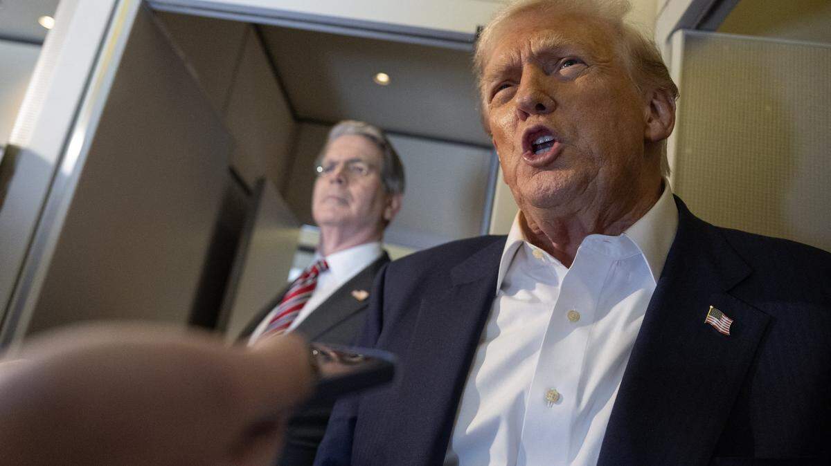 US President Donald Trump speaks as US Treasury Secretary Scott Bessent (L) looks on as they talk to the media aboard Air Force One as he flies to Japan on October 27, 2025. Donald Trump headed to Japan on October 27, the next leg of an Asia tour that could see the US president and China's Xi Jinping end the bruising trade war between the world's largest economies. (Photo by ANDREW CABALLERO-REYNOLDS / AFP) (Photo by ANDREW CABALLERO-REYNOLDS/AFP via Getty Images)