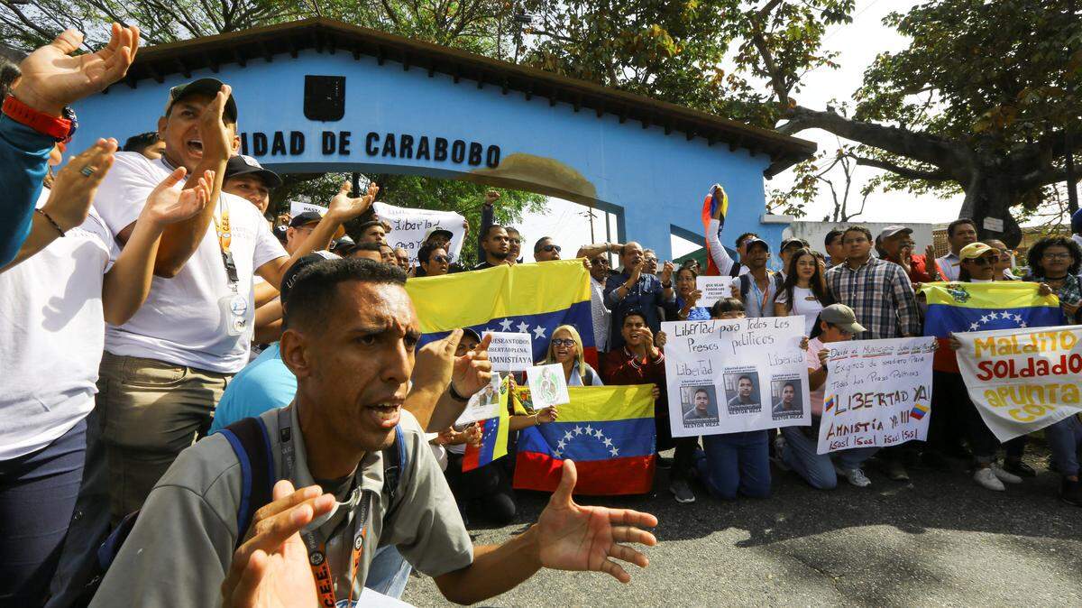 Brenda Meza sostiene una pancarta con fotos de su hijo encarcelado Nestor Meza durante una protesta estudiantil en la Universidad de Carabobo, en Valencia, Venezuela, 4 de febrero de 2026.