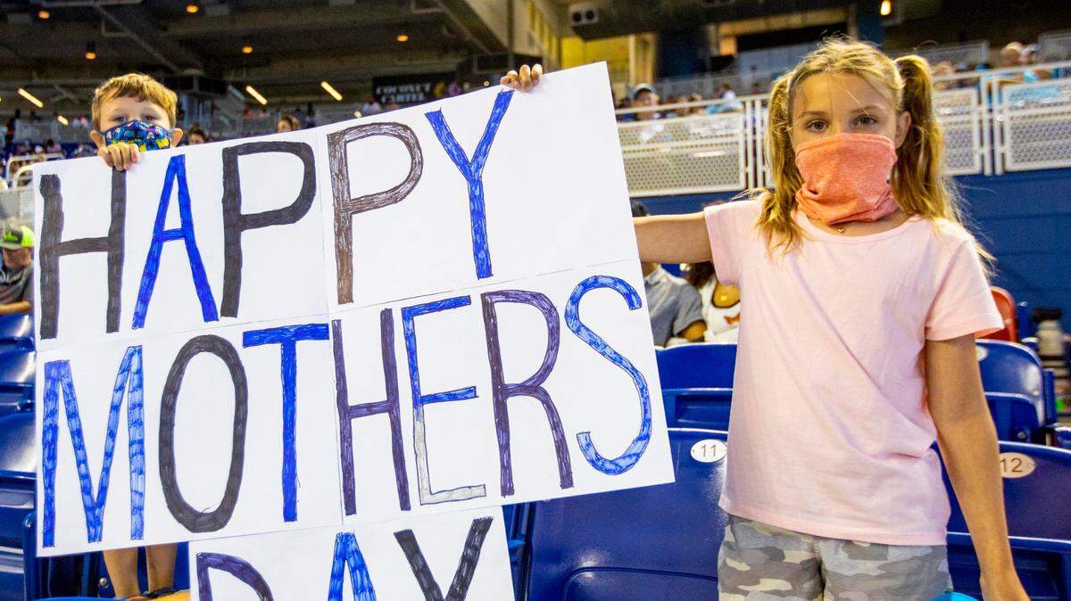 Niños sostienen un cartel con el lema “Feliz Día de la Madre” el estadio LoanDepot en Miami, Florida, el Domingo, 9 de mayo de 2021