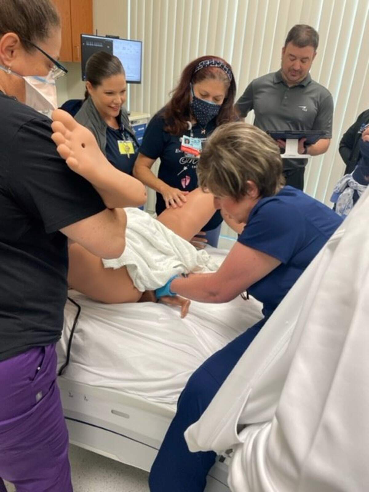 Los estudiantes del programa de becas de enfermería del Memorial Healthcare System observan una simulación de un parto. El programa de un año, que comenzó en agosto de 2021 para combatir la creciente escasez de enfermeros, los prepara para trabajar en áreas especializadas a través de instrucción en clase, entrenamiento práctico y entrenamiento de simulación.