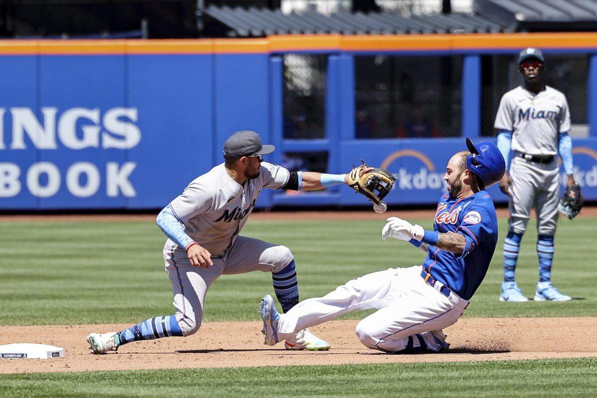 El torpedero de los Marlins Miguel Rojas poen out en segunda base a Tomas Nido, de los Mets, en el partido celebrado el 19 de junio de 2022 en Nueva York.