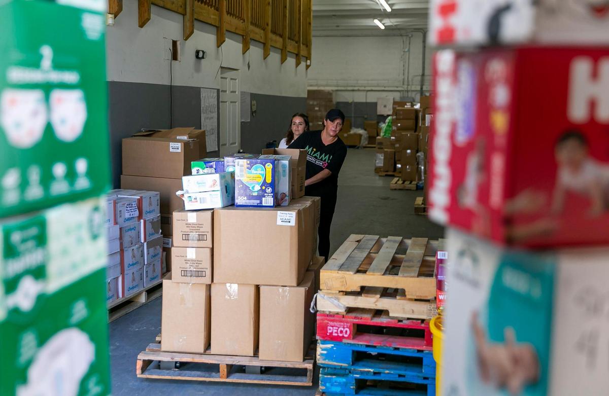 Ashley Ramos, izquierda, y Mary Province, derecha, empleadas de Miami Diaper Bank, se preparan para cargar un camión que visita su almacén para obtener más de 19,000 pañales donados. Miércoles 17 de agosto de 2022 en Hialeah, Florida.