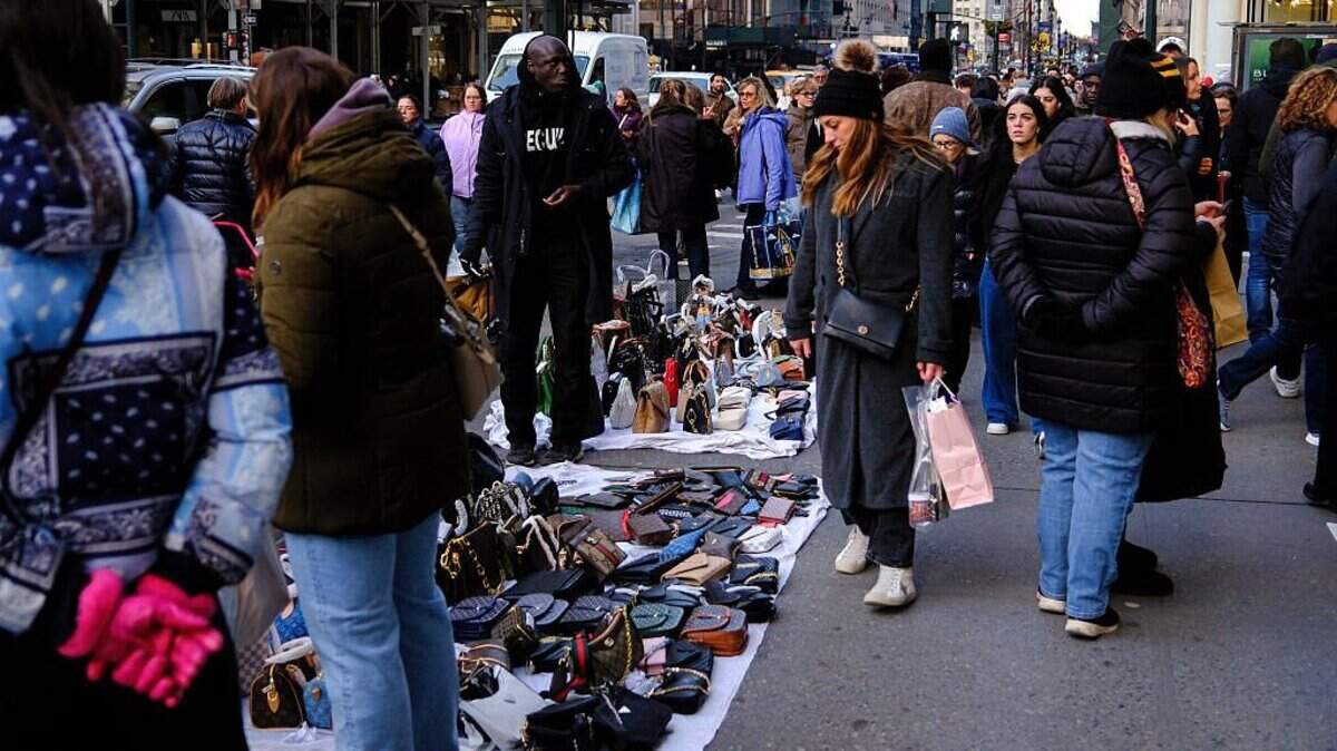 Peatones observan artículos vendidos por vendedores ambulantes en una calle del distrito de Manhattan, en la ciudad de Nueva York, el 6 de diciembre de 2025.
