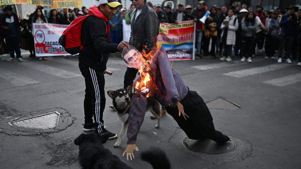 Demonstrators set on fire a human-sized wooden figure depicting Bolivia's Rodrigo Paz during a protest against the government called by teachers in La Paz on May 27, 2026. Bolivian President Rodrigo Paz warned on May 27 that the crisis "is reaching a breaking point," amid another day of demonstrations calling for his resignation, despite the possibility that he might declare a state of emergency to quell the protests. (Photo by Marvin RECINOS / AFP via Getty Images)