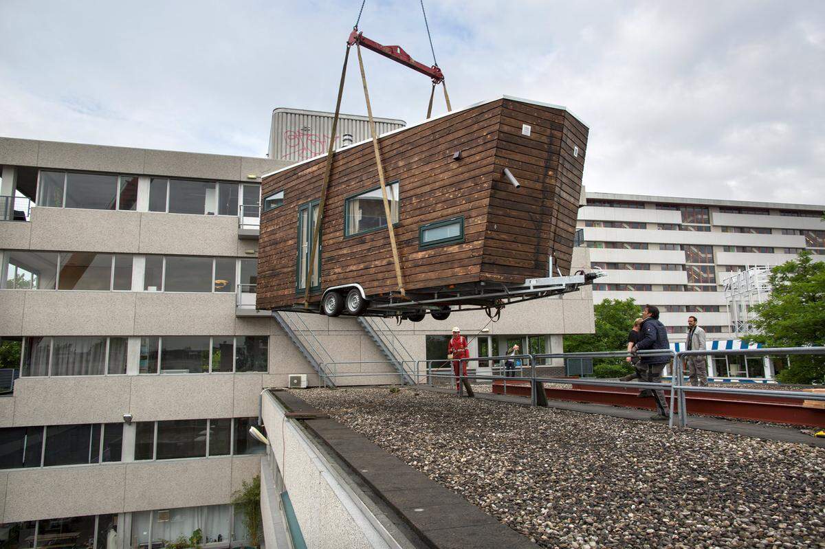Subiendo una vivienda estilo mobile home compacta a la azotea durante un ensayo.