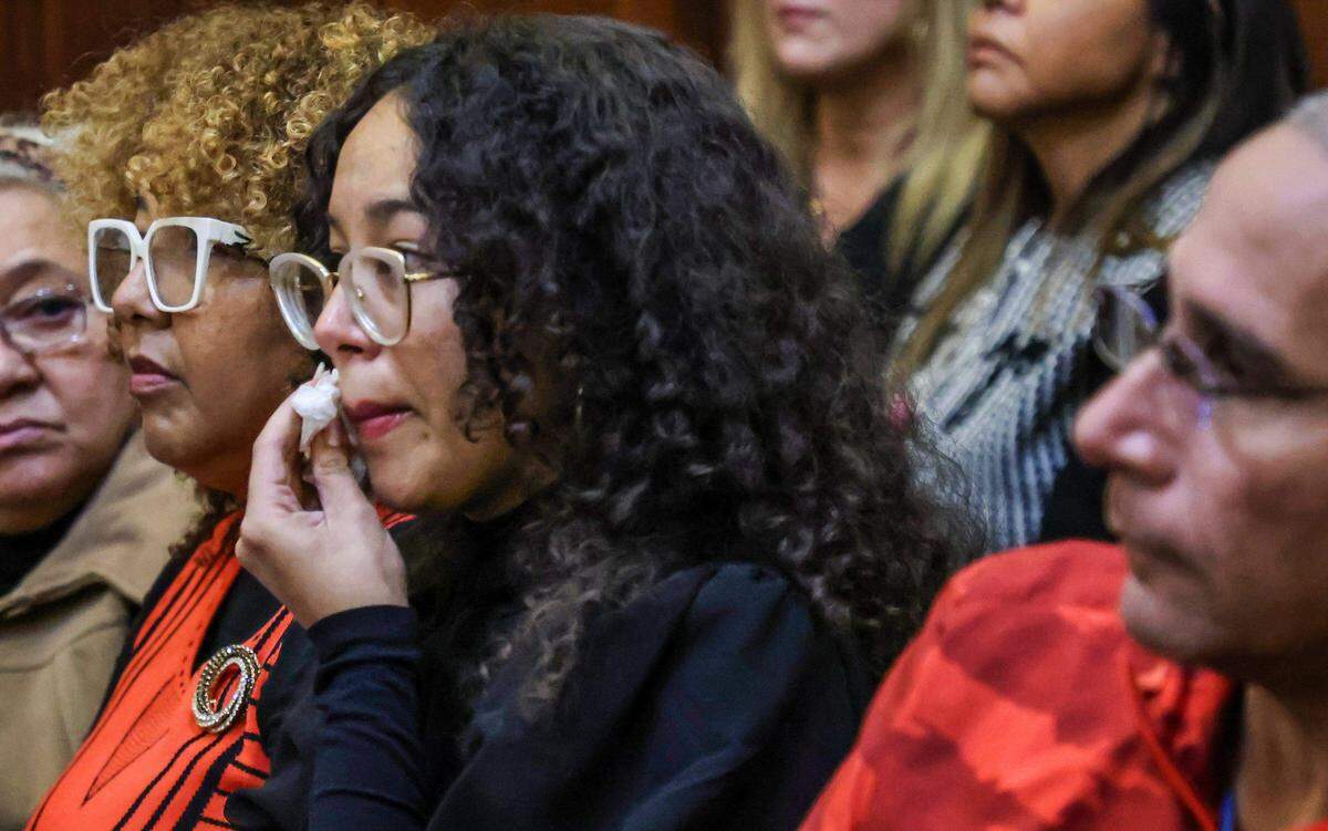Angélica Lugo, en el centro, y Odalis Benavides, a la izquierda, hija y esposa de Osmel Lugo Gutiérrez, se sientan juntas mientras Angélica se seca las lágrimas durante la sentencia de Lugo Gutiérrez el miércoles 14 de enero de 2026. el acusado fue declarado culpable de homicidio involuntario por la muerte de Franklyn Piñeyro dentro de un supermercado Publix en Coral Gables en 2022.